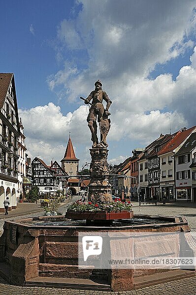 Röhrbrunnen  mit einem Ritter auf dem Schild das Stadtwappen  1582  hinten das Haigeracher Tor aus den 17. Jhd. und Fachwerkhäuser  Gengenbach  Baden-Württemberg  Deutschland  Europa