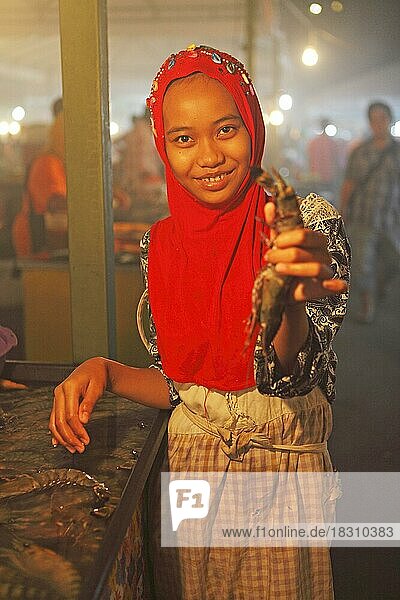 Malaysische Frau mit Kopftuch zeigt eine Languste auf dem Filipino Nachtmarkt  Kota Kinabalu  Sabah  Borneo  Malaysia  Asien
