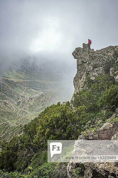 Weibliche Touristin blickt von einer Klippe im Nebel über das Tal im Nationalpark Macizo de Anaga auf der Insel Teneriffa auf den Kanarischen Inseln  Spanien  Europa