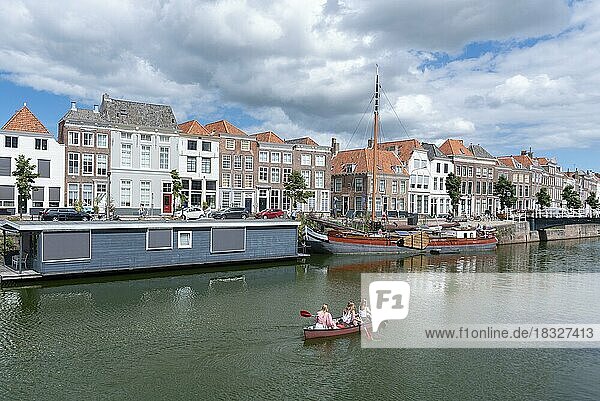 Canoe in front of historic house facades and houseboats at Londensekaai  Middelburg  Zeeland  Netherlands