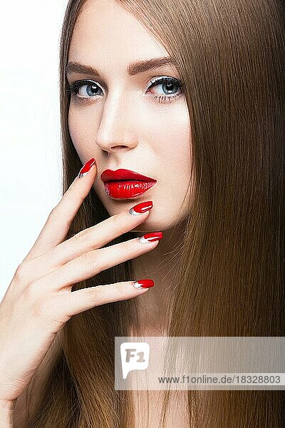 Schönes junges Mädchen mit einem hellen Make-up und roten Nägeln. Bild im Studio auf einem weißen Hintergrund aufgenommen