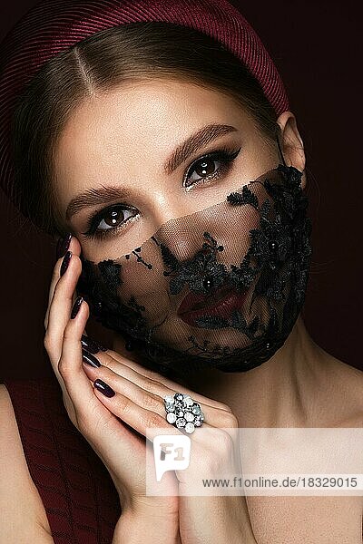 Porträt einer schönen Frau mit einer schwarzen Spitzenmaske und klassischem Make-up. Maskenmodus während der Covid-Pandemie