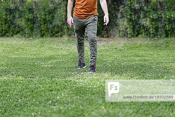 Mann Beine gehen zur Kamera über grünes Gras