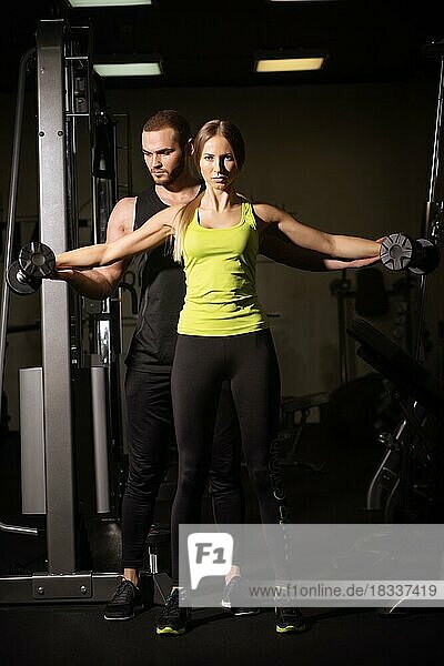 Sporty sexy man and woman with great abdominal muscles in black sportswear