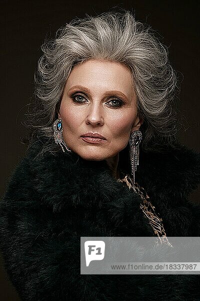 Porträt einer schönen älteren Frau in einer Leopardenbluse und einem Pelzmantel mit klassischem Make-up und grauem Haar