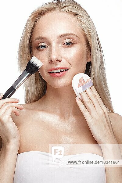 Schönes junges Mädchen mit einem leichten natürlichen Make-up  Pinsel für Kosmetik und nackte Maniküre. Schönheit Gesicht. Bild im Studio auf einem weißen Hintergrund genommen