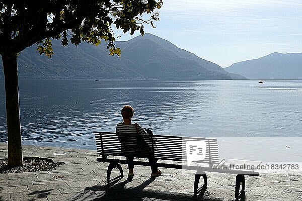 Bench with woman on the lakeshore of Ascona  Ticino  Switzerland  Europe