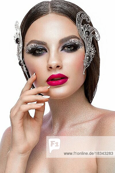 Beautiful girl with creative art make-up and silver accessories. Beauty face. Photos shot in studio