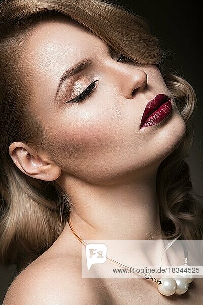 Beautiful blonde in a Hollywood manner with curls  red lips. Beauty face. Picture taken in the studio