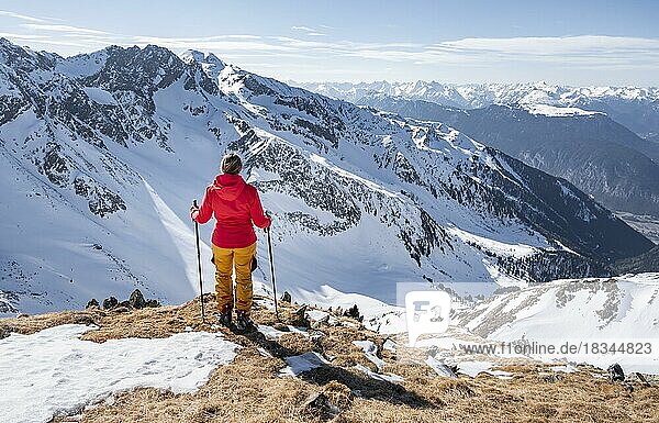 Skitourengeherin steht neben Gipfelkreuz  Gipfel des Mitterzeigerkogel im Winter  Sellraintal  Kühtai  Tirol  Österreich  Europa