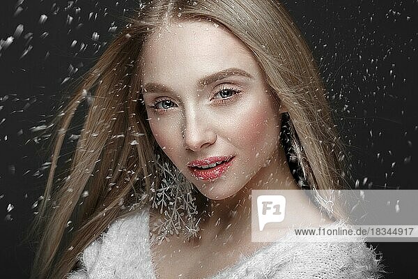 Schönes blondes Mädchen in einem Winterbild mit Schnee. Schönes Gesicht. Foto im Studio aufgenommen