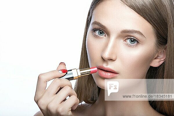 Schönes junges Mädchen mit einem leichten natürlichen Make-up und Beauty-Tools in der Hand. Bild im Studio auf einem weißen Hintergrund aufgenommen