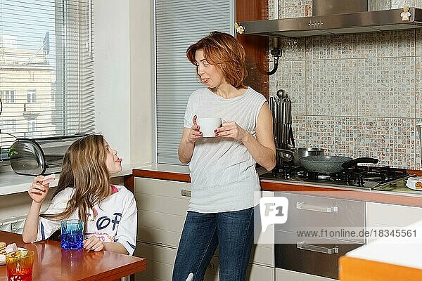 Mutter und ihre Tochter in der Küche verziehen das Gesicht