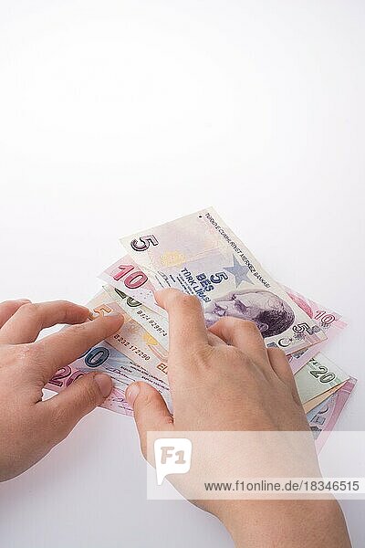 Hand hält türkische Lira-Banknoten auf weißem Hintergrund