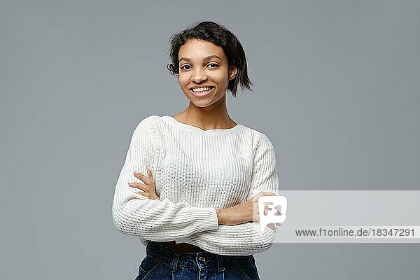 Porträt einer schönen glücklichen schwarzen Frau  die mit verschränkten Armen steht