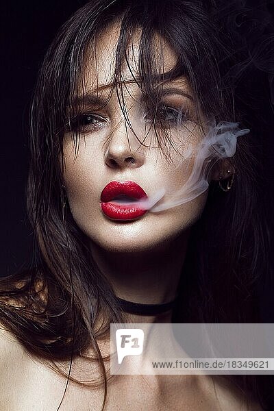 Schöne sexy brunette Mädchen mit hellen Make-up  rote Lippen  Rauchen mit Rauch aus dem Mund. Schönheit Gesicht. Fotos im Studio auf einem schwarzen Hintergrund geschossen