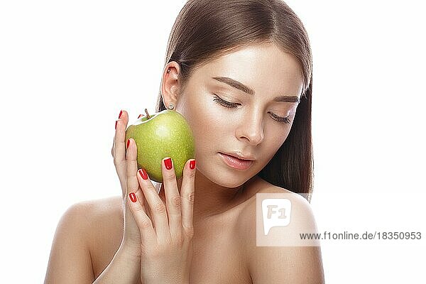 Schönes junges Mädchen mit einem leichten natürlichen Make-up und perfekter Haut mit Apfel in der Hand. Schönes Gesicht. Bild im Studio auf einem weißen Hintergrund genommen