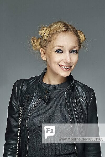 Portrait of smiling blonde girl in leather jacket and curls of hair