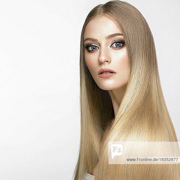 Beautiful blond girl with a perfectly smooth hair  and classic make-up. Beauty face. Picture taken in the studio