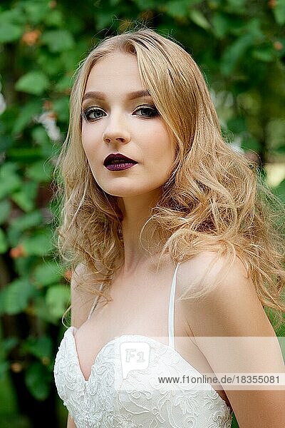 Close up portrait of a beautiful fashion bride in park. Wedding make up and hair