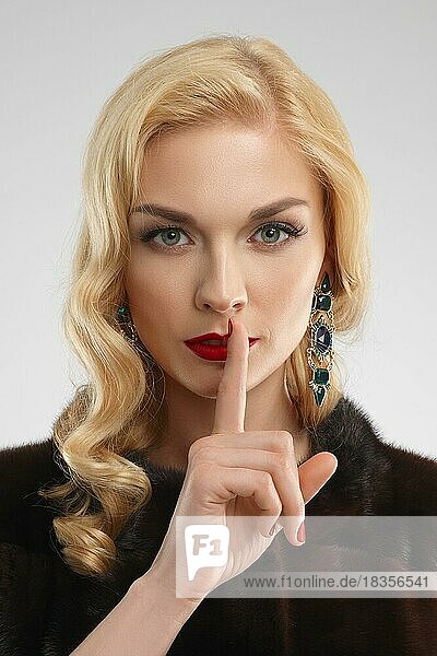 Close up Porträt eines schönen Mädchens mit Finger an den Lippen. Schweigen Zeichen