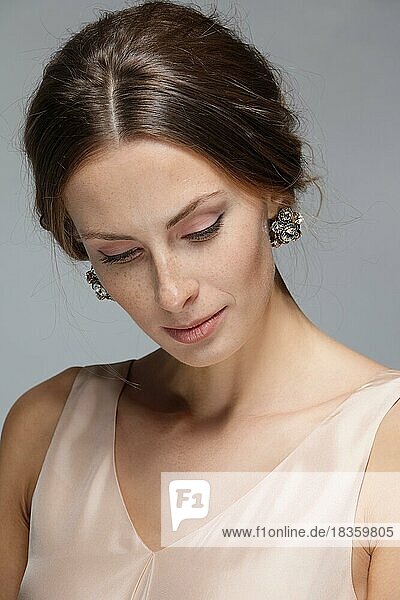 Gesicht einer schönen jungen Frau in beigefarbenem Peignoire. Schönheit Porträt  frische Haut. Natürliches Make-up