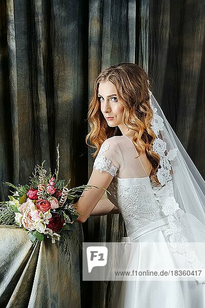Portrait of pretty bride in wedding dress with flower coronet in profile