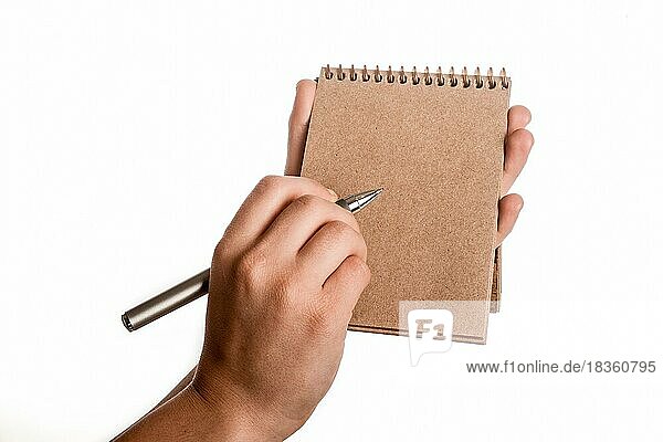 Spiralförmige braune Notizbuch und einen Stift in der Hand des Kindes auf einem weißen Hintergrund
