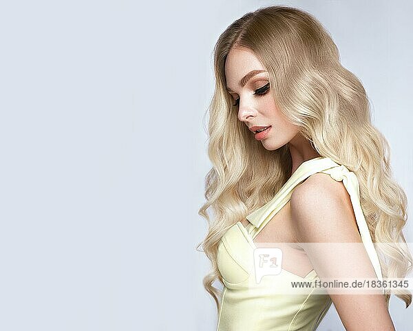 Schönes blondes Mädchen mit perfekt gelocktem Haar und klassischem Make-up. Schönheit Gesicht und Haar. Bild im Studio aufgenommen