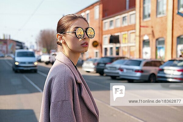 Junges Mädchen beim Überqueren der Straße. Spiegel Sonnenbrille mit Straße reflektiert in ihm