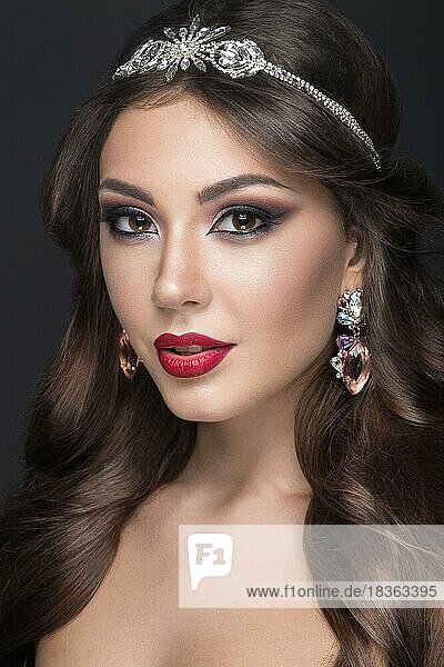 Schöne Frau mit arabischem Make-up  roten Lippen und Locken. Schönes Gesicht. Bild im Studio auf einem grauen Hintergrund genommen