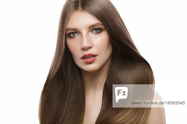 Beautiful brown-haired girl with a perfectly smooth hair  and classic make-up. Beauty face and hair. Picture taken in the studio on a white background
