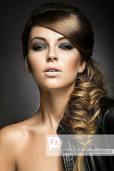Schönes Mädchen mit hellen Make-up  perfekte Haut und Frisur wie ein braid.picture im Studio auf einem grauen Hintergrund genommen