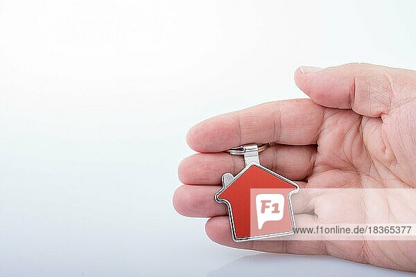 Immobilienkonzept mit einem Metallhaus-Symbol in der Hand