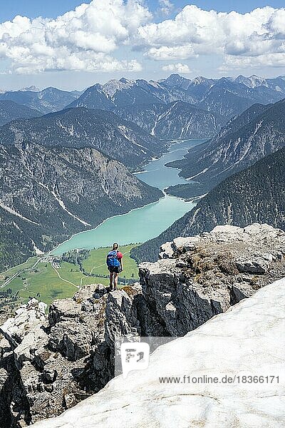 Hiker at a rock edge  view from Thaneller to Plansee and eastern Lechtal Alps  Tyrol  Austria  Europe