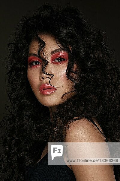 Porträt einer schönen asiatischen Frau mit rotem Make-up und Locken. Beauty face.photo im Studio aufgenommen