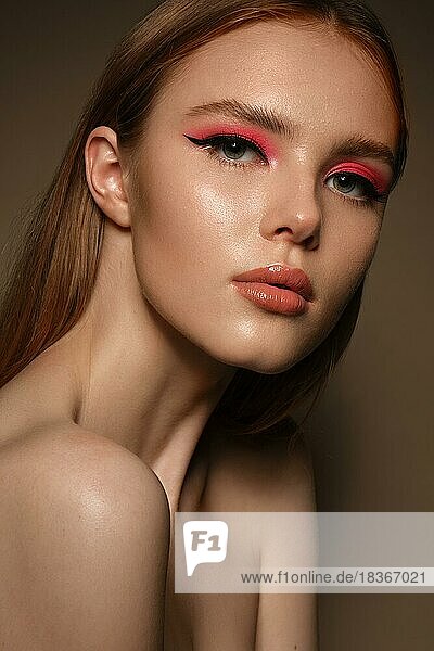 Porträt einer schönen Frau mit rosa kreativen Make-up. Schönes Gesicht. Fotos im Studio geschossen