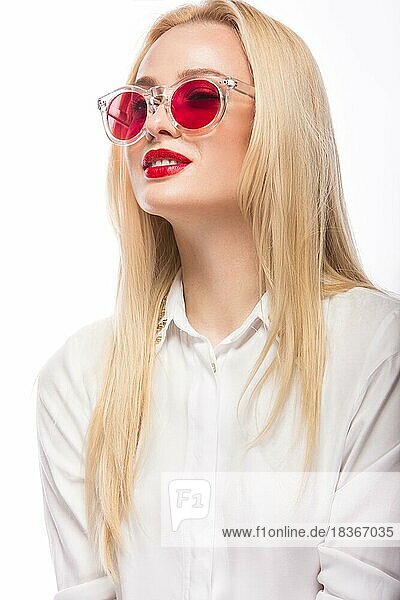 Schönes blondes Mädchen mit rosa Brille und weißem Hemd. Schönheit im Gesicht. vor weißem Hintergrund