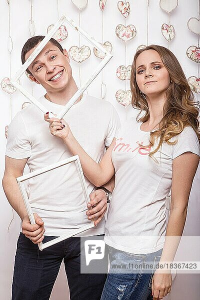 Young  beautiful woman and man in love on Valentine's Day  Laughing Happy Lovers  showing different poses. Picture taken in the studio with decorations