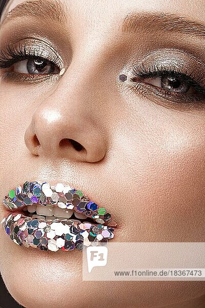 Schönes Mädchen mit kreativen Glitter Make-up Lippen. Schönes Gesicht. Fotos im Studio geschossen