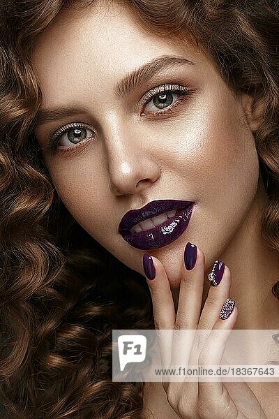 Schönes Mädchen mit Abend-Make-up  lila Lippen  Locken und Design Maniküre Nägel. Schönheit Gesicht. Fotos im Studio geschossen