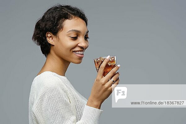Closeup-Porträt der jungen afroamerikanischen Frau mit einem Glas Cola mit Eis in der Hand