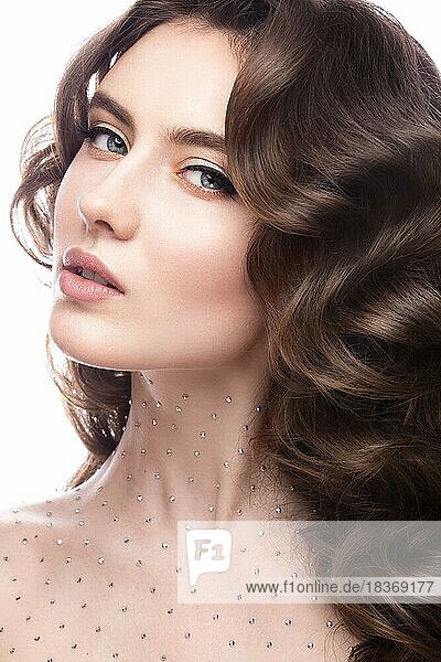 Portrait of a beautiful girl with a gentle make-up  curls and crystals on the body. The beauty of the face. Photos shot in the studio