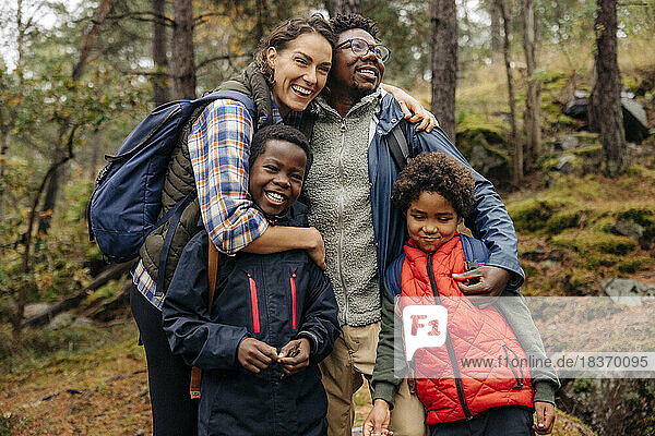 Glückliche Familie  die sich beim Wandern im Wald umarmt