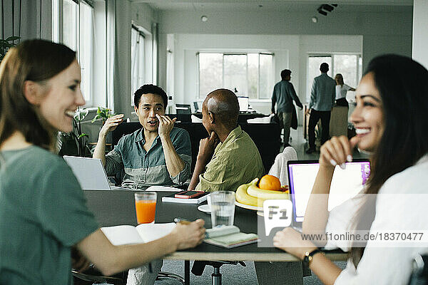 Geschäftskollegen gestikulieren und sprechen während einer Besprechung im Büro miteinander