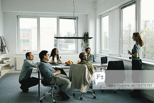 Geschäftsfrau beim Brainstorming mit männlichen und weiblichen Kollegen während einer Sitzung im Büro