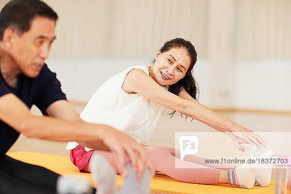 Japanese senior couple training at indoor gym
