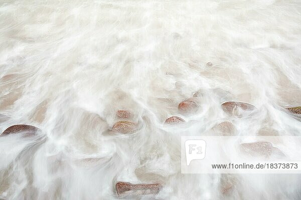 Detail of the swell on a red stone beach on the north-west coast of Scotland