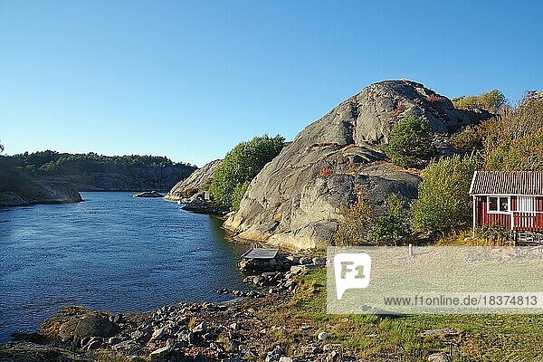 Gerundete Granitfelsen  seichte Buchten und kleine Hütte am Ufer eines Fjordes  Schärenküste  Bohulän  Schweden  Europa