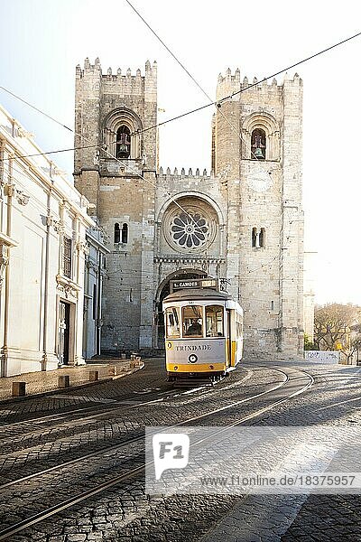 Häuserfronten  enge Straßen  Gassen und Treppen  in einer Historischen Altstadt. schöner Urbaner Ort Alfama am Morgen mit Straßenbahn  der berühmten Tram 28 vor der Kathedrale von Lissabon Sé de Lisboa in der hauptstadt Lissabon  Portugal  Europa